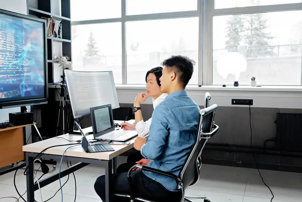 Development team members reviewing a wilderness map layout on screen